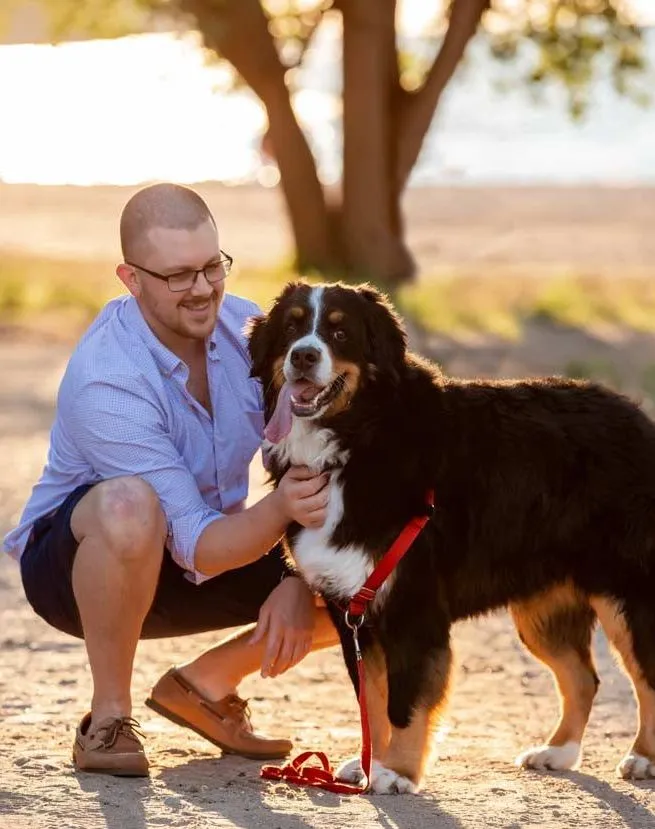 Benjamin Simerly kneeling beside Millie by the lake